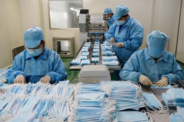 3月10日,在江西康蓝医疗器械,工人们正在口罩生产线上忙. .